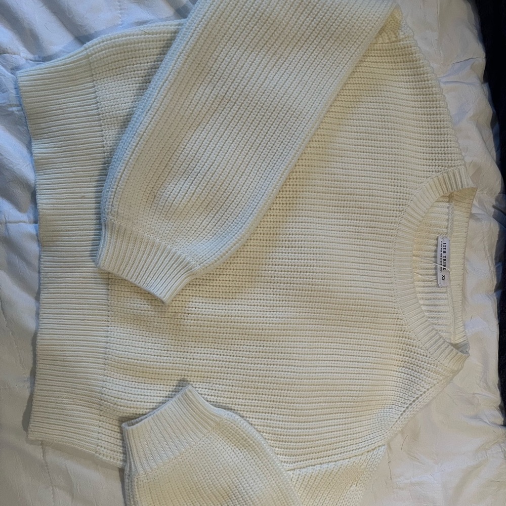 White knit sweater slit on one shoulder